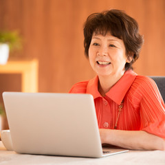 ノートパソコンを操作するシニア女性