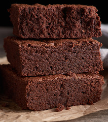 stack of baked square pieces of chocolate brownie cake