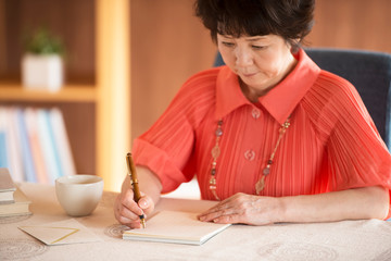 手紙を書くシニア女性