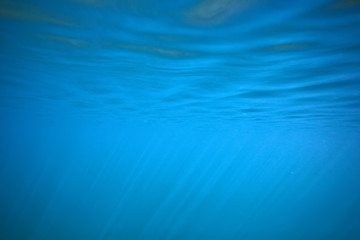 ocean water blue background underwater rays sun / abstract blue background nature water