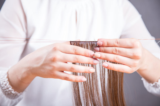 Tkanie peruki. Dłonie perukarki. 