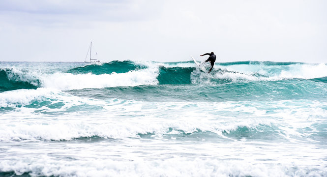 Man Surfing On Rough Waves