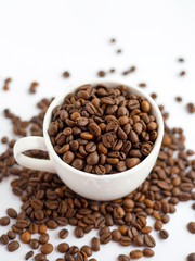 Coffee beans in white cup isolated on white background, drinks concept