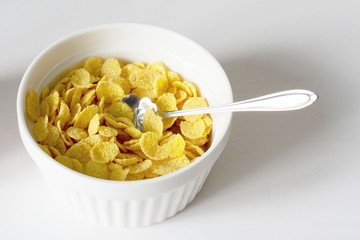 Healthy breakfast with cornflakes and milk over white background