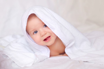 Fototapeta na wymiar little baby smiling under a white towel
