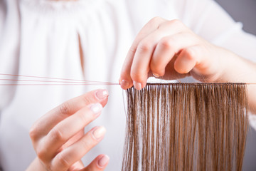 Fototapeta premium Dłonie młodej kobiety robiącej perukę