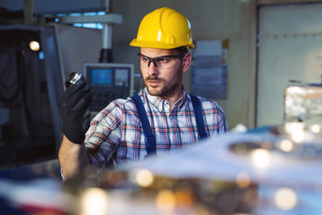 Factory engineer checks the quality of the manufactured part