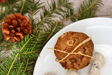 Fototapeta na wymiar Christmas decorations - oat biscuits for Santa Claus and branches of coniferous trees