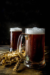 Two Homemade craft beer mugs, dark wooden background copy space