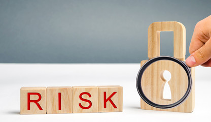 Wooden blocks with the word Risk and lock. Imperfect security system. High risk of hacking and theft of personal data. Insecure passwords. Risky investment. Suspicious Security Certificates