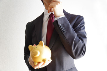 ビジネスマンとブタの貯金箱