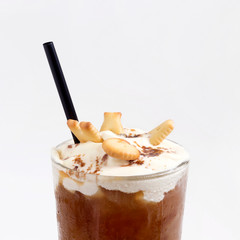 Glass of cold coffee drink with whipped cream, syrup and cookies on white background. Beverages,...