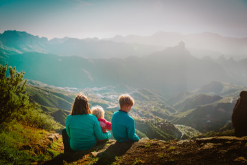 Mother with kids travel in mountains, family hiking in nature
