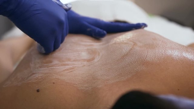 Female masseur hands making massage in the spa salon.