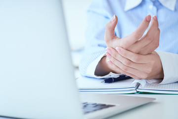 Obraz premium Young woman holding her wrist close-up . Pain from using computer. Office syndrome hand pain by occupational disease.