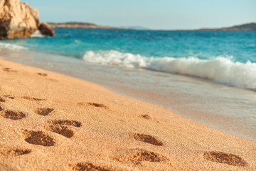 Footprints from people on the azure beach. Concept of relaxing on sea coast in summer. Beach of Kaputas, Turkey