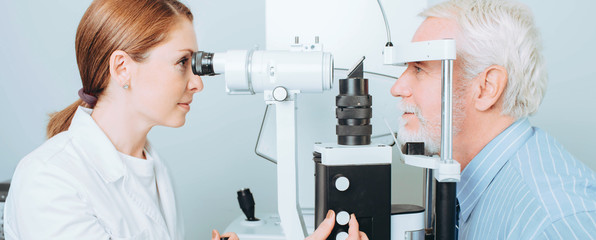 Senior patient checking vision with special eye equipment