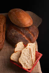 Different bread and wheat on the rustic table. Selective focus, close up