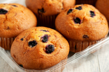 Muffins in the package. Cupcakes with currant berries or blueberries in a package close-up. Muffins for breakfast. Baking with berries.