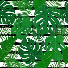 Vector seamless pattern with tropical green leaves on black strips background. Summer print with exotic tropic plants and graphic ornate for print, textile, fabric, decor, design.