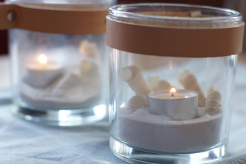 Two glasses with burning candles on the table, gently blue gamma