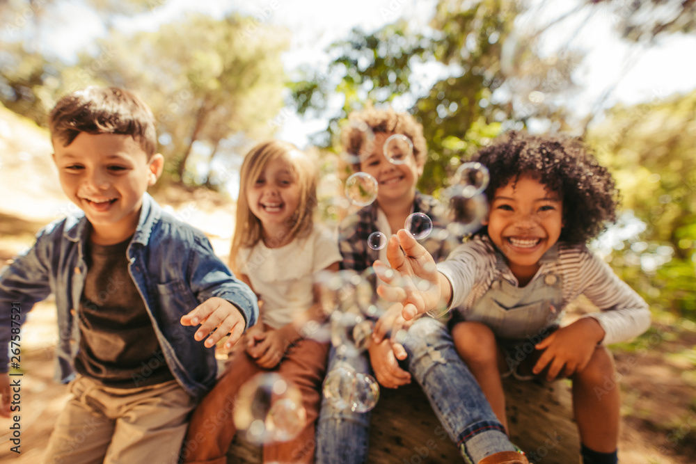 Poster group of children playing with soap bubbles