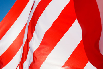 Naklejka premium American flag flying in the wind against a blue sky