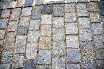 Road paved with paving stones. Cobbles background.