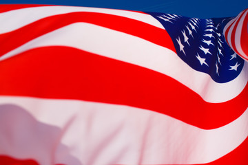 American flag flying in the wind against a blue sky