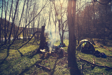tourists in a hiking to halt food cooked on the campfire. group in camp