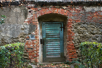 Fototapeta na wymiar shabby door in an old abandoned brick building.