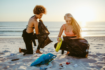 Girls picking up trash from the beach