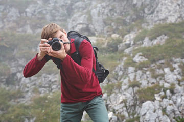 traveling man take a photograph the nature of mountains in the fog.