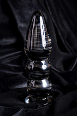 Clear colored Butt plug made of glass on a black background