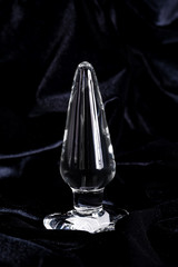 Clear colored Butt plug made of glass on a black background