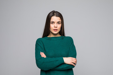 Young pretty woman with crossed hands wearing in green sweater isolated on gray background