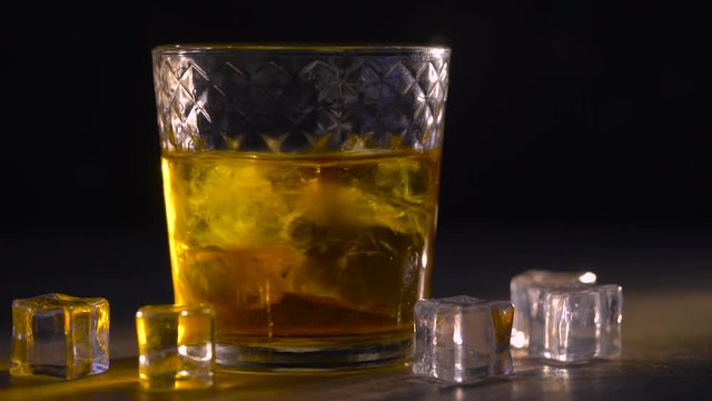 Cinemagraph. Whiskey in glass with ice cubes