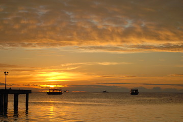 Colourful sunset on th eIndian ocean island wih clouds ocean and boats