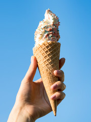 hand holding an ice cream cone of strawberry