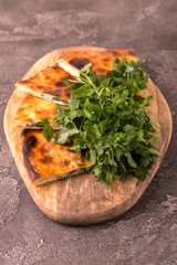 Khachapuri Megrelian with spinach and parsley. Pita bread with cheese