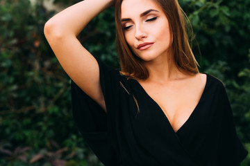 Fototapeta premium Close-up girl with a make-up in black dress. she closed her eyes