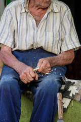 hands of a man carving an object from wood