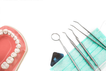 Dentist tools on mask and x-ray photo.