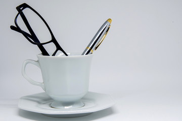 Xícara em cima de livro com objetos