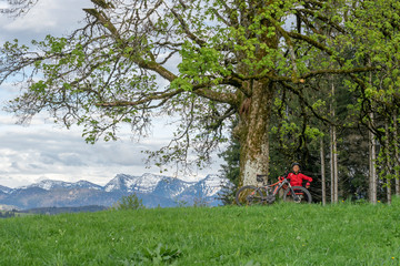 senior woman mountainbiking on a e-mountainbike in early spring, in the Allgaeu Area, a part of the bavarian alps,Germany