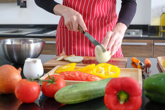 woman cutting onion for cook salad in the kitchen - Powered by Adobe