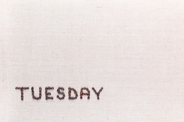The word Tuesday written with coffee beans , aligned at the bottom left.