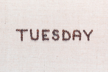 The word Thursday written with coffee beans , aligned in the center, closeup.