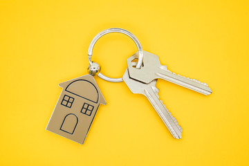 key chain with house symbol and keys on yellow