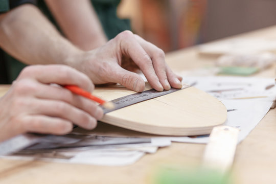 Close up hands of unknown male carpenters make a skateboard on an exclusive order. Concept hobby for youth and handmade